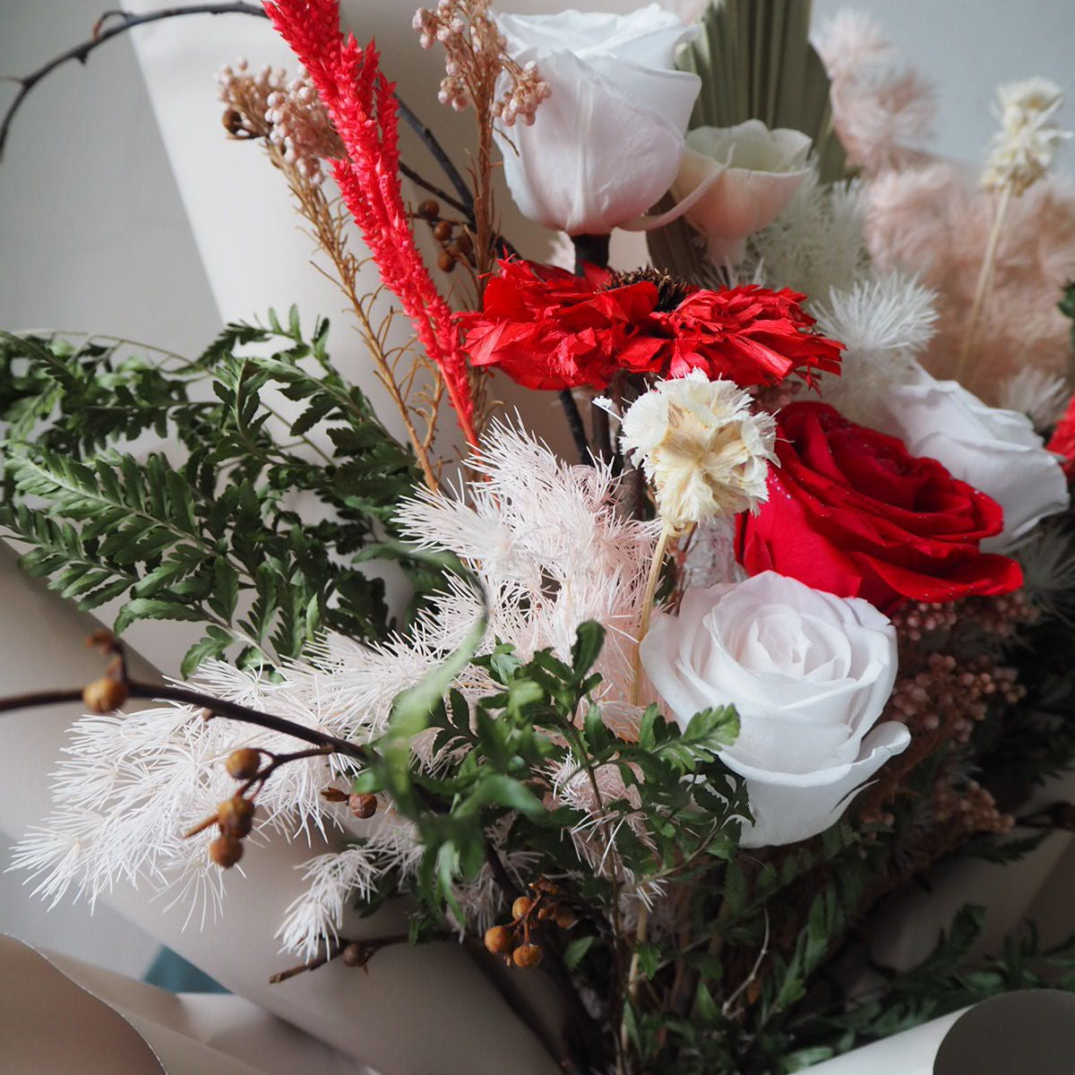Bouquet of flowers with red and white roses on a white surface