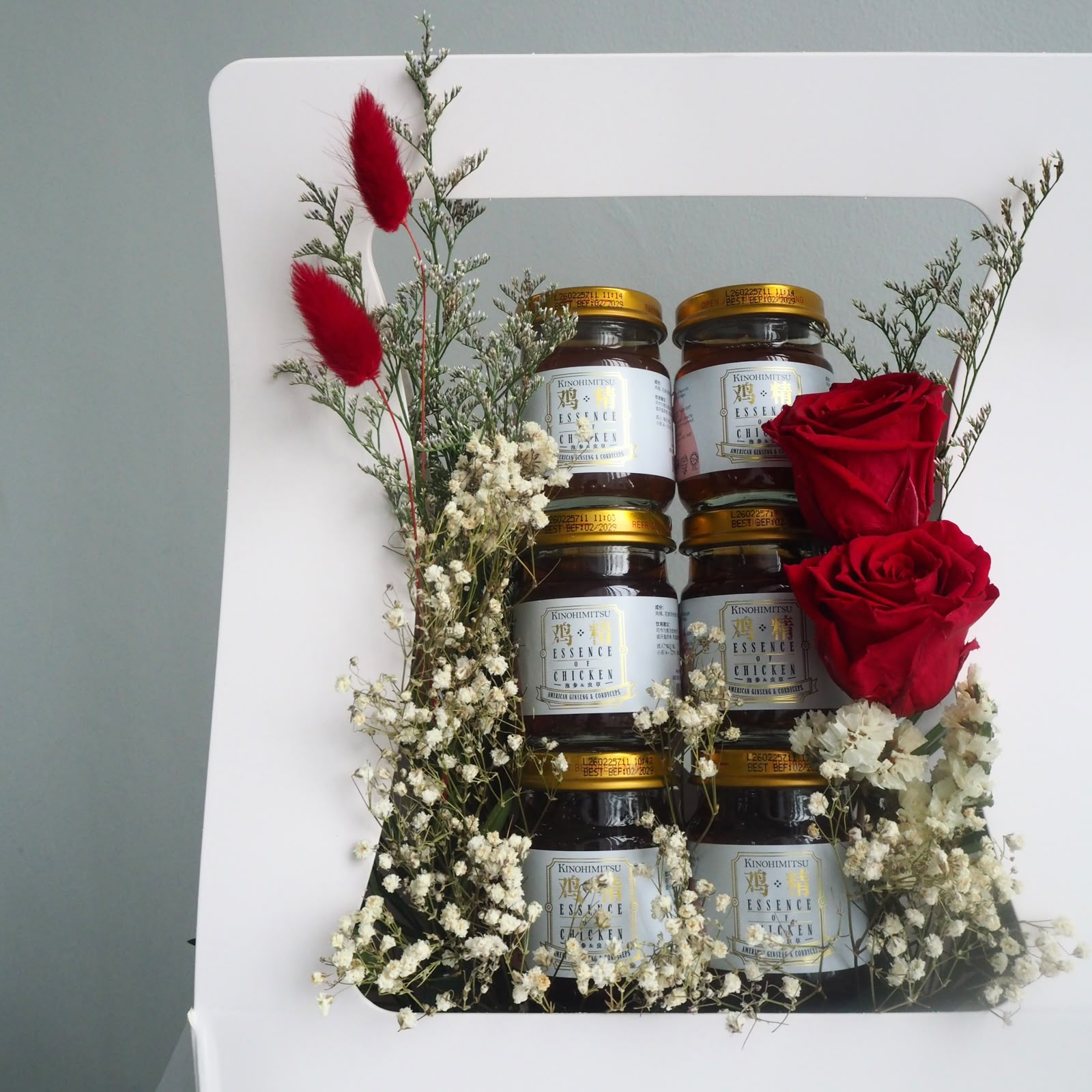 chicken essences with red roses in flower box