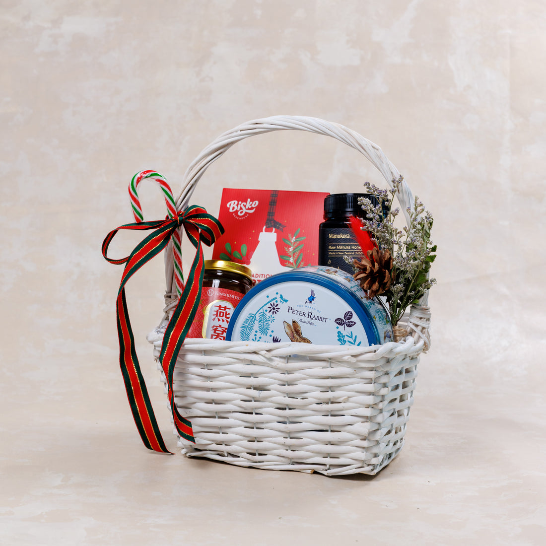 Gift basket with various items including a bottle, jar, and box on a light background