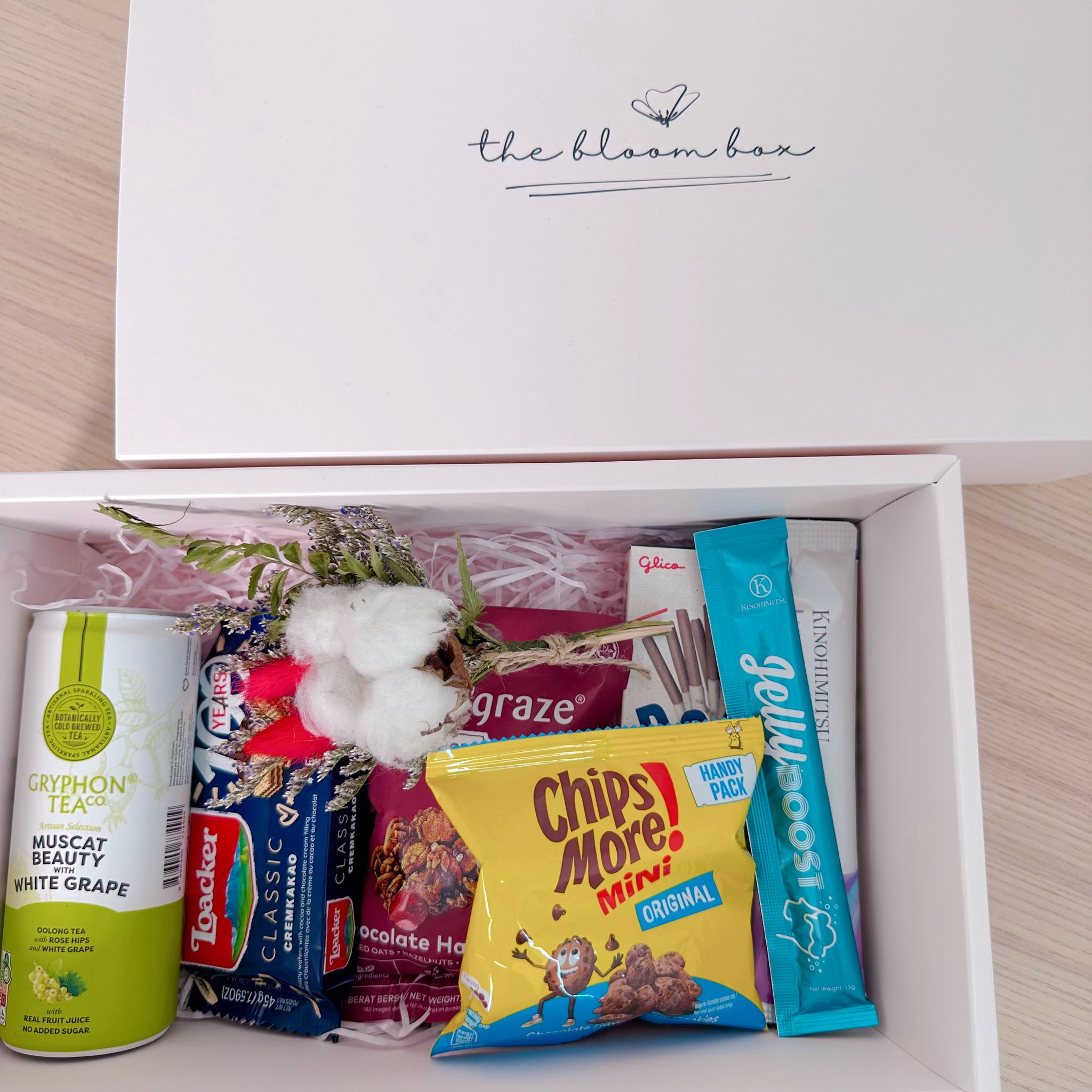 Open box containing snacks and tea with &