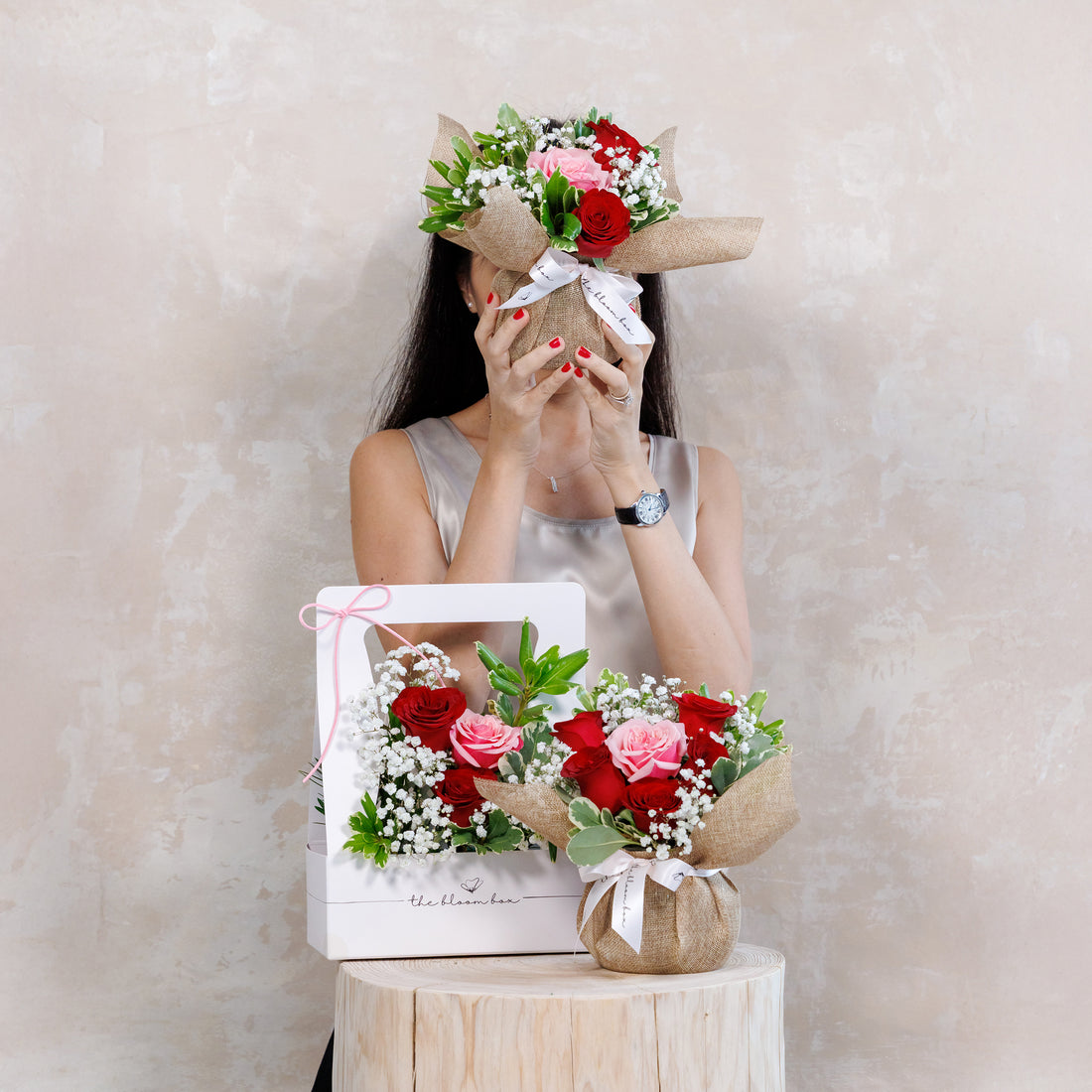 Woman holding a bouquet of flowers with a plain background