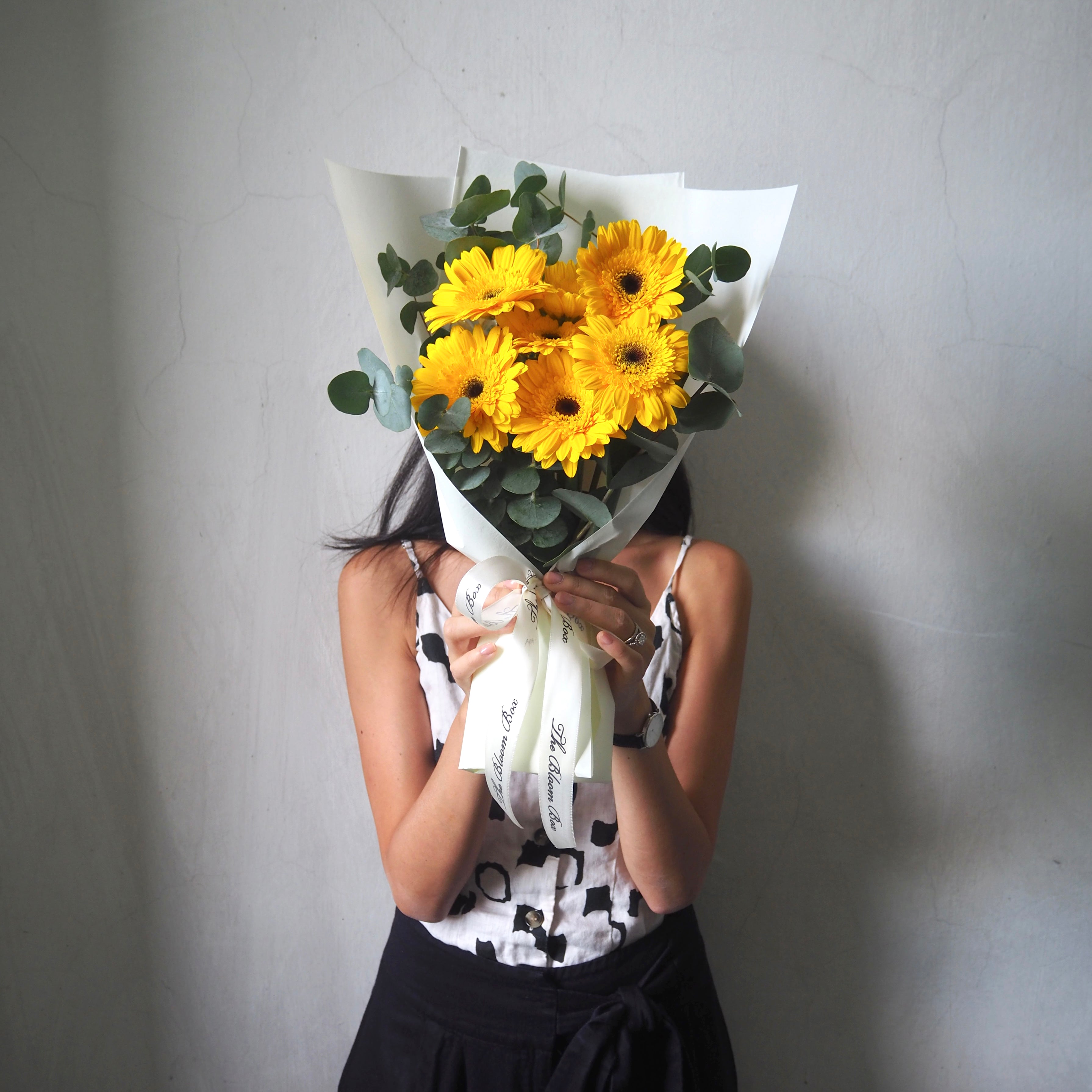 lady holding yellow gerbera bouquet