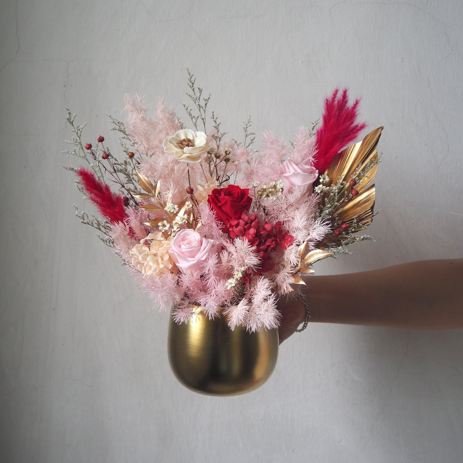 preserved red and pink rose flower arrangement in gold vase