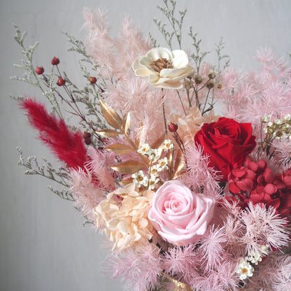 close up of preserved flower arrangement with red and pink rose