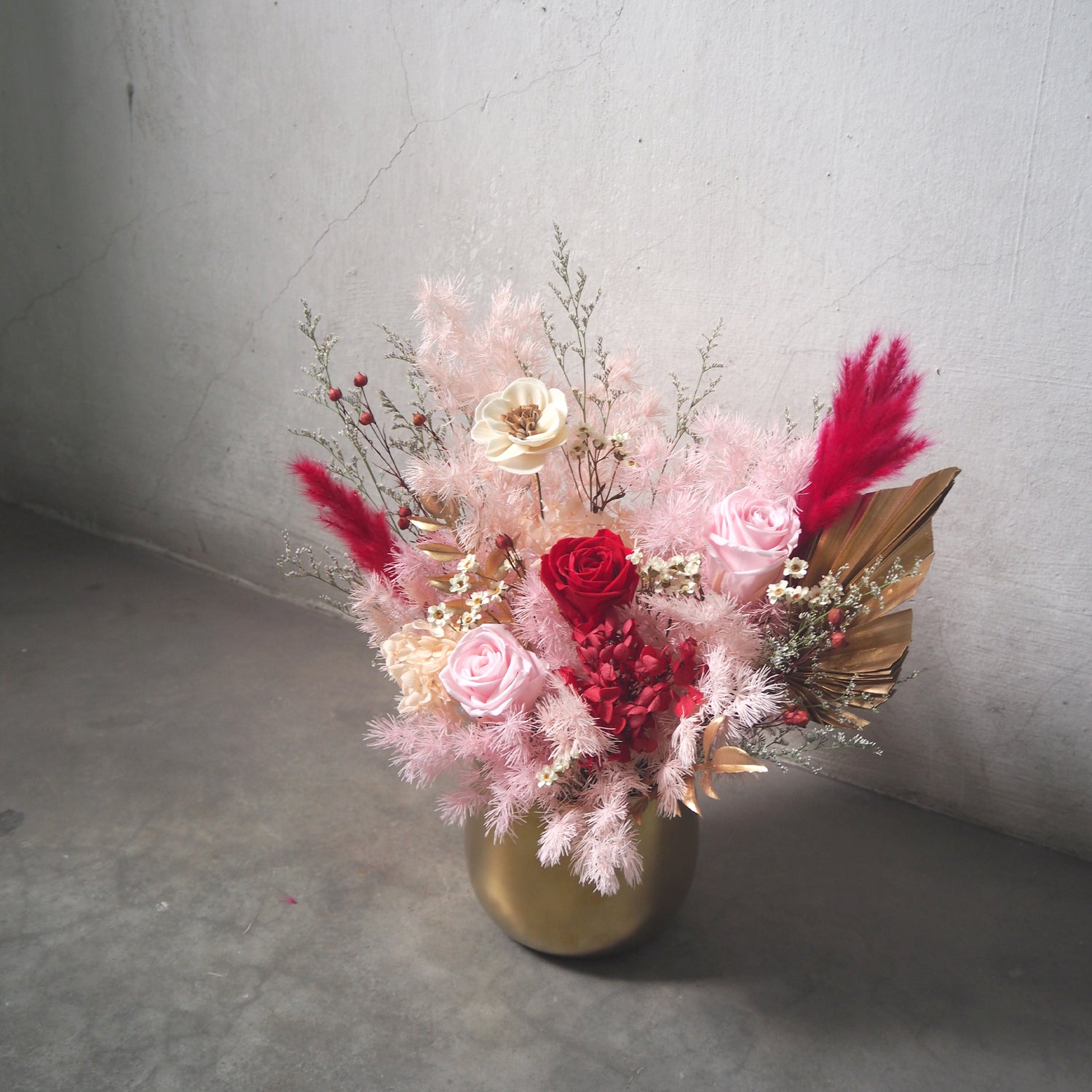 side view of preserved flower arrangement in gold vase