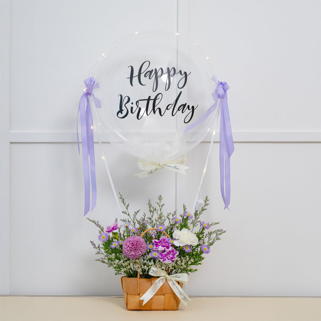 mini purple flower arrangement with happy birthday balloon decorated with fairy lights