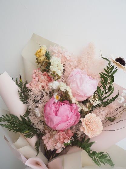 Bouquet of pink and white flowers with green leaves on a light background
