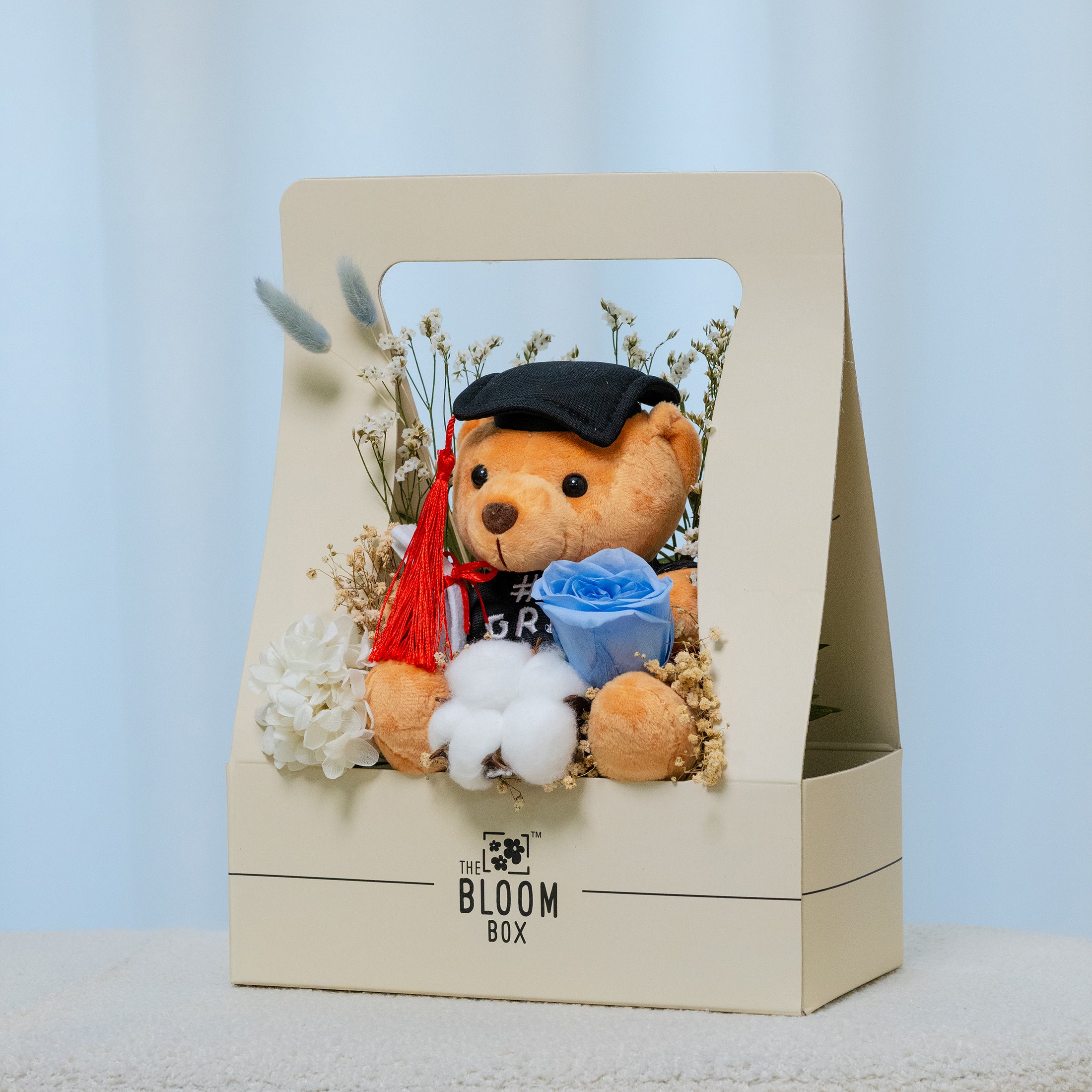 side view of grad bear in blue bloom box