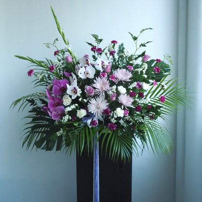 Iris condolence flower stand with white-purple phalaenopsis orchids and muted purple tones