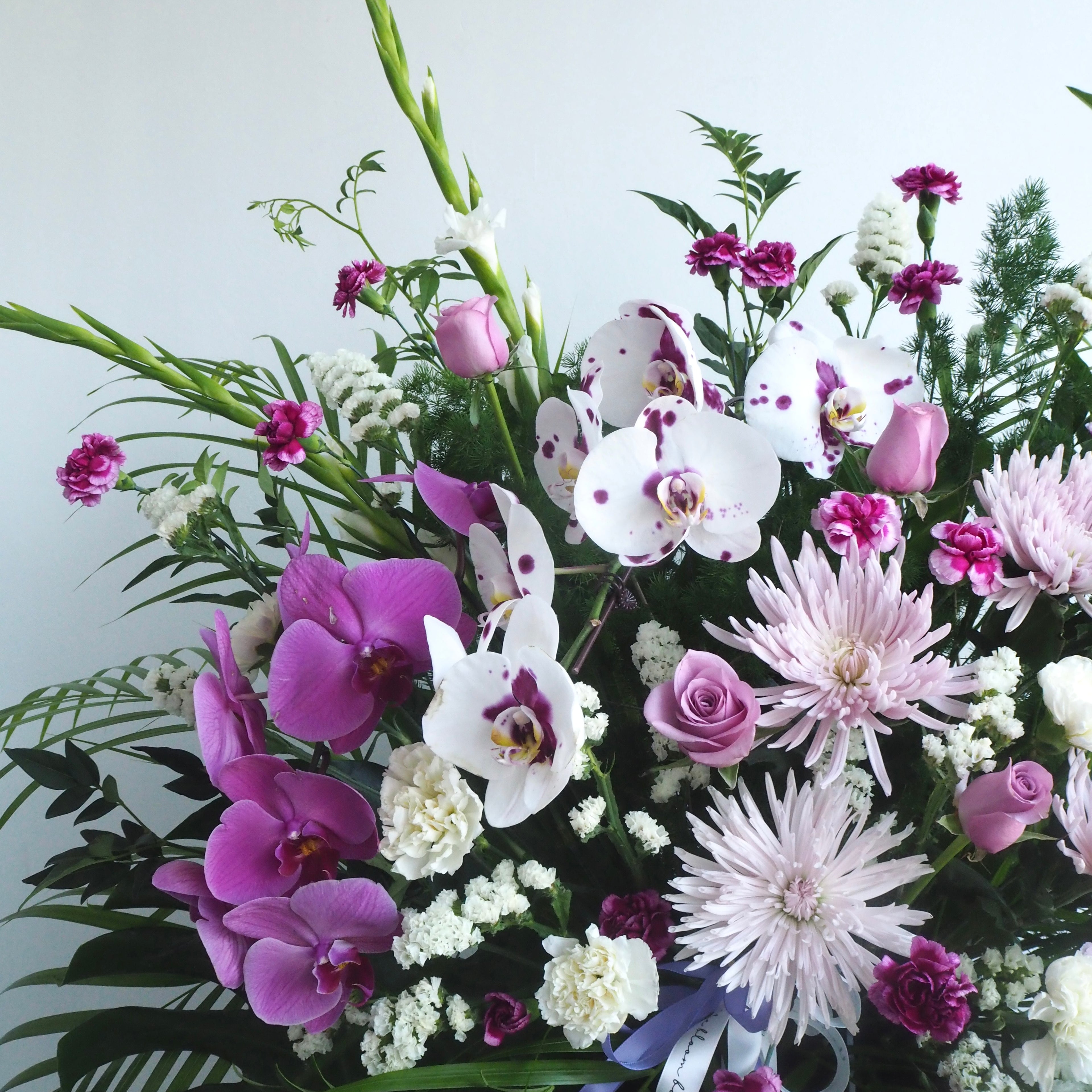Close-up of white-purple orchid phalaenopsis in Iris condolence flowers arrangement