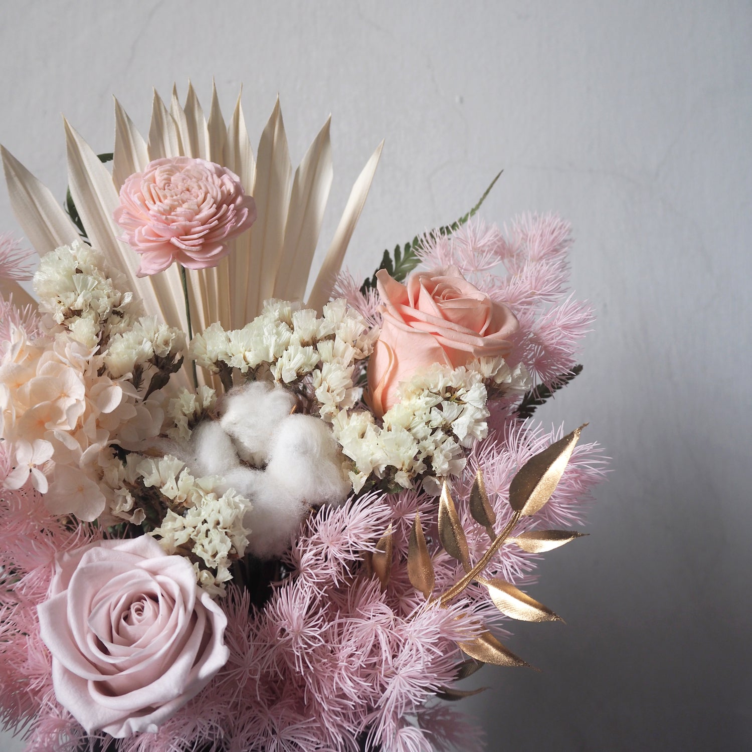 close up of pink preserved flower arrangement in sleek black vase