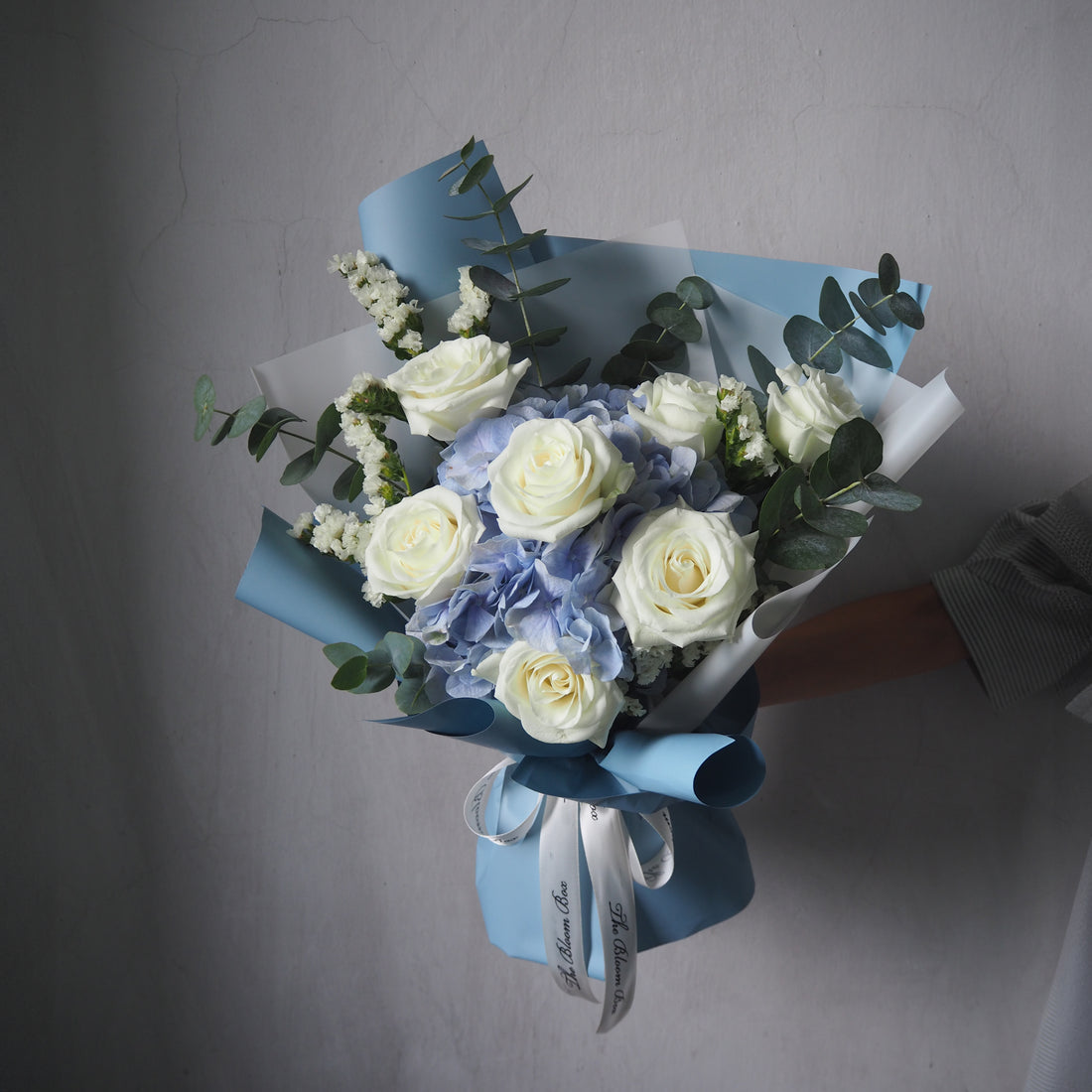 blue hydrangea and white roses with blue wrapper style bouquet