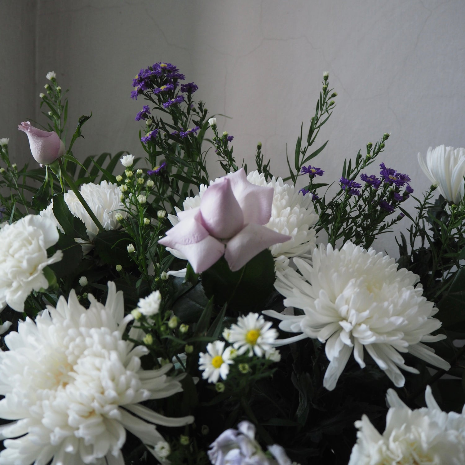 Bouquet of white and purple flowers against a neutral background