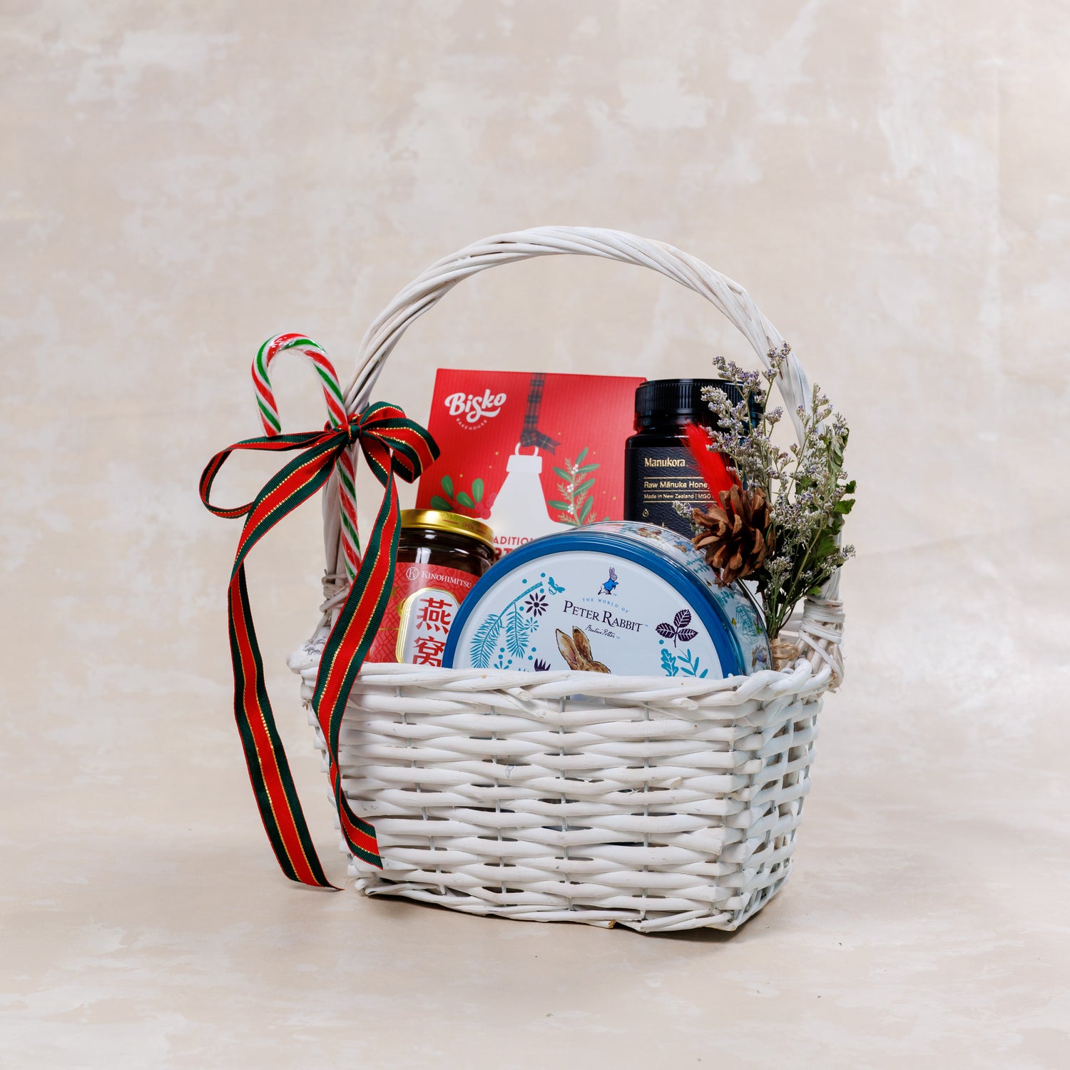 Gift basket with various items including a bottle, jar, and box on a light background