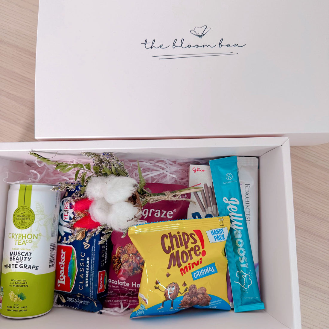 Open box containing snacks and tea with &