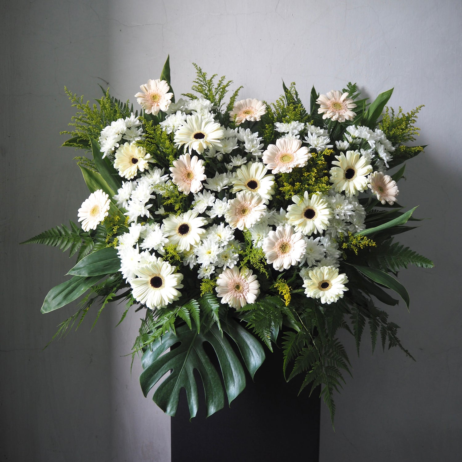 Floral stand of white and green flowers on a gray background