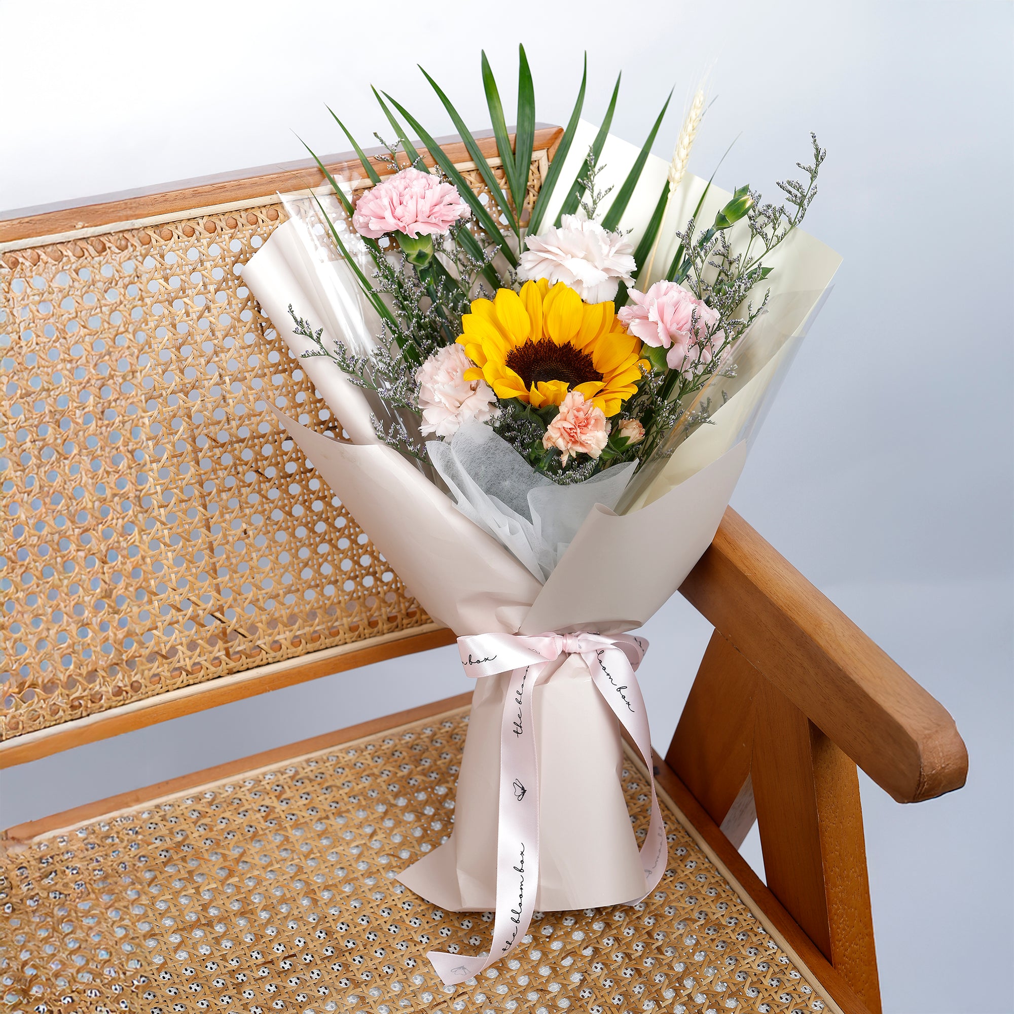 Bouquet of flowers with a sunflower on a wicker chair