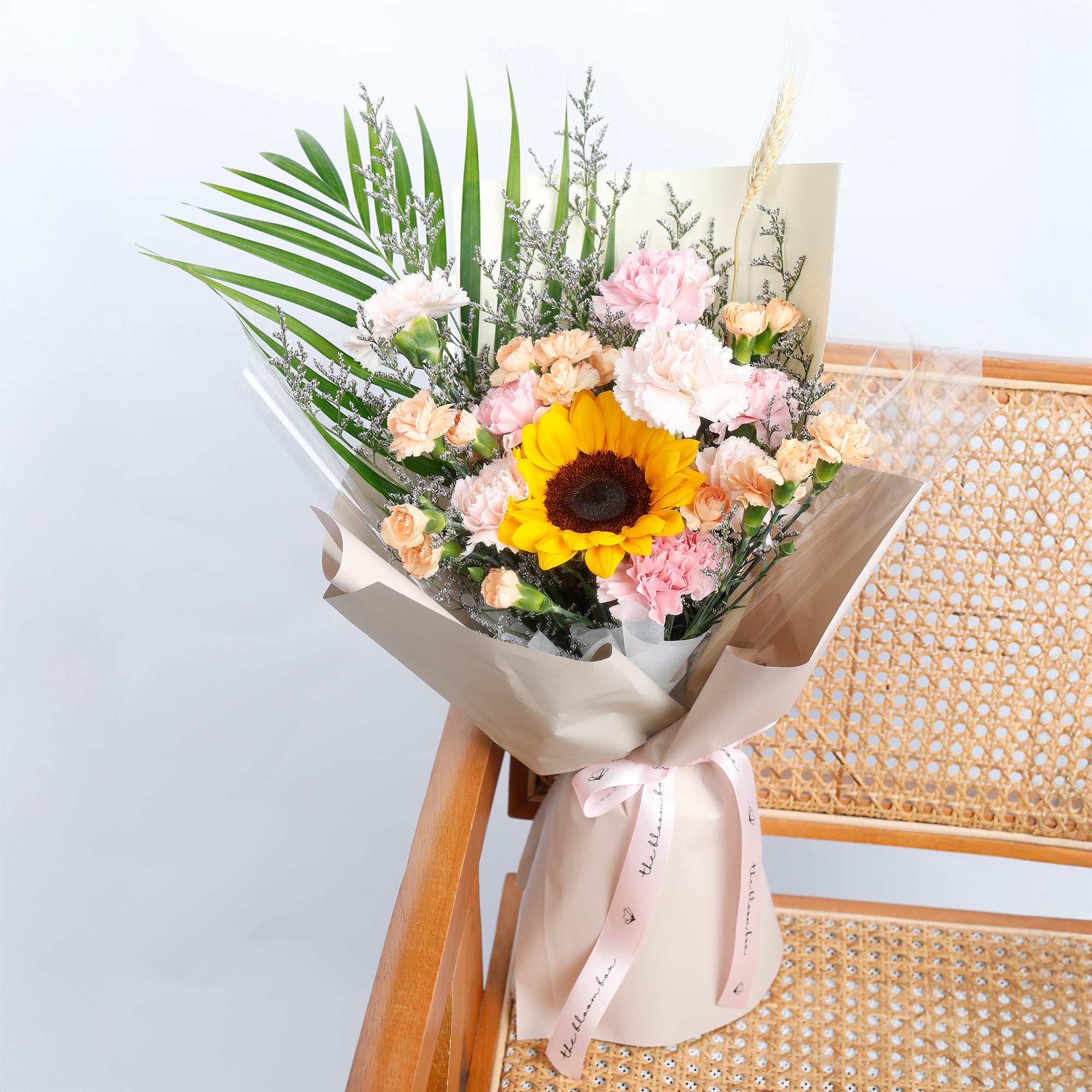 Bouquet of flowers with a sunflower on a light background