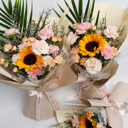 Two bouquets of flowers with sunflowers and pink carnations on a white background