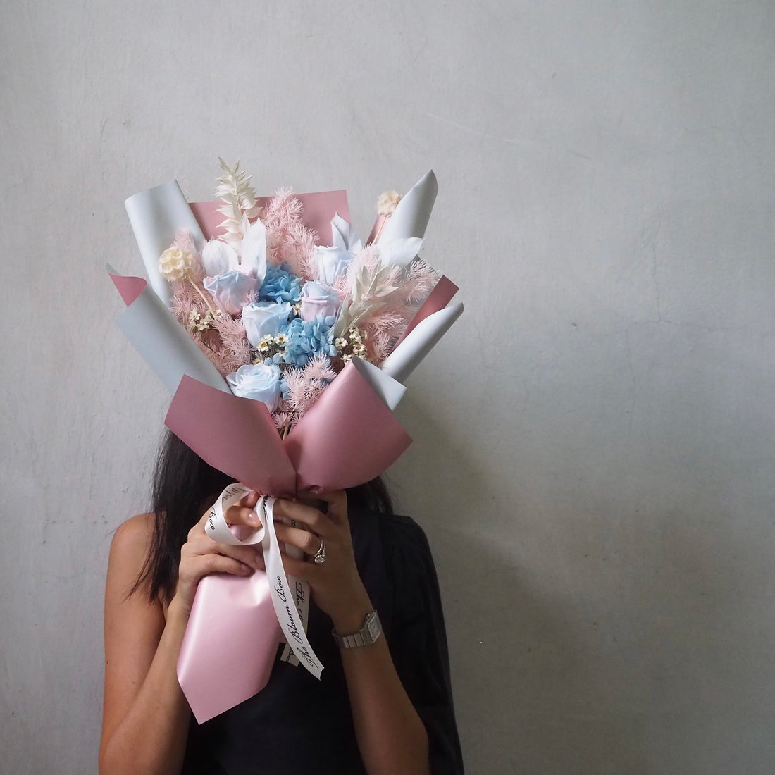 lady holding blue pink unicorn colours preserved flower bouquet