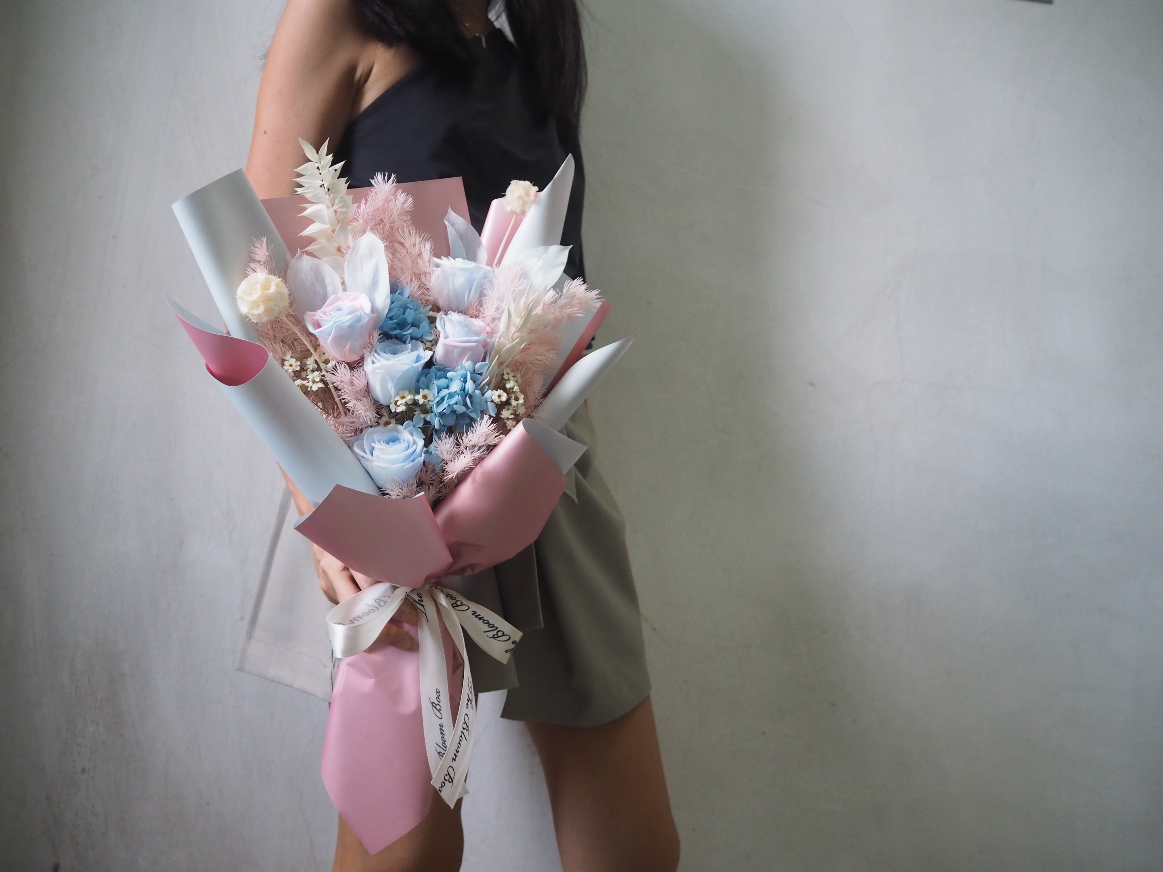 lady holding with pink blue roses bouquet on one hand