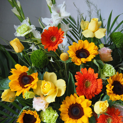 Bouquet of colorful flowers including sunflowers, roses, and daisies.