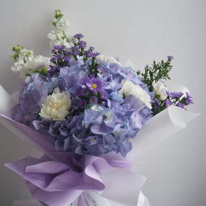 Close-up of purple hydrangea and white matthiola flowers in Wisteria bouquet